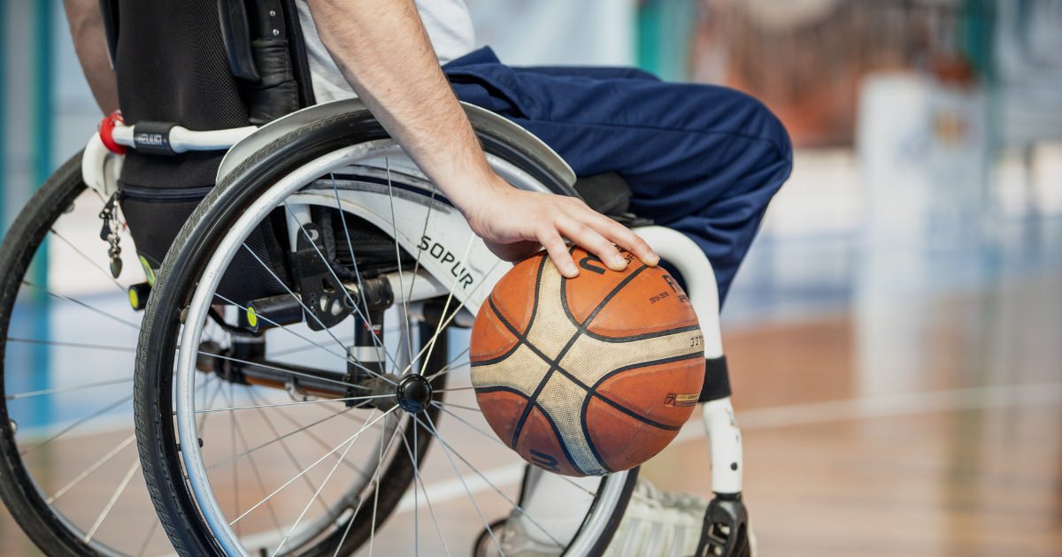 man in a wheelshair palming a basketball