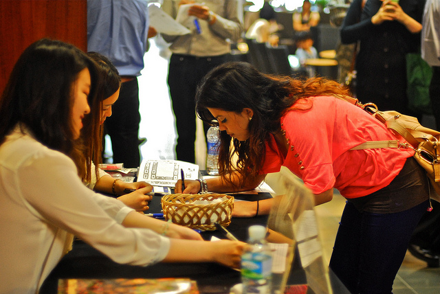 Woman at job fair signing up to receive more information at a booth