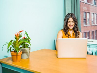 Woman working at her laptop and smiling
