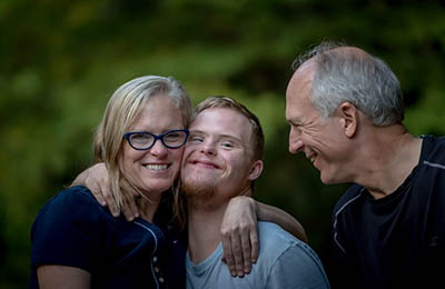 Man, woman and son hugging and smiling