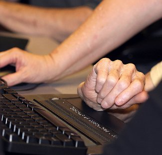 Close-up of a hand using a braille keyboard
