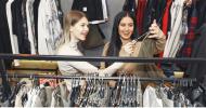 Two women shopping through a clothes rack