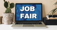 A laptop computer with the words, “Job Fair” on a blue background. To the left is a cactus. 